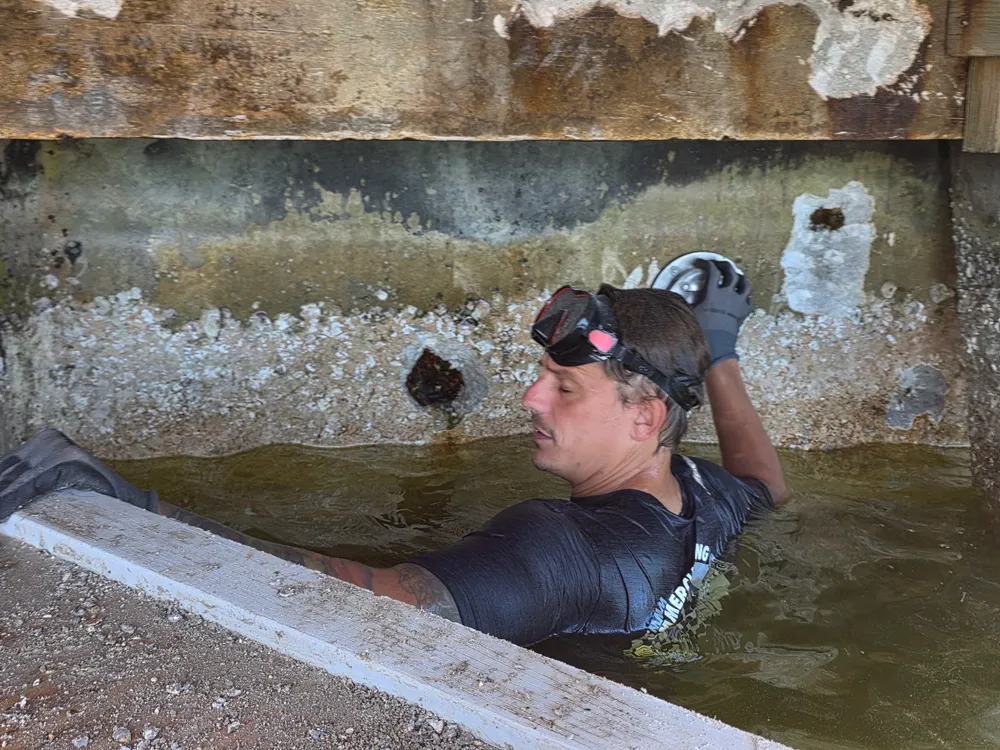 Underwater inspection diver conducting class-required survey on commercial vessel in South Florida port